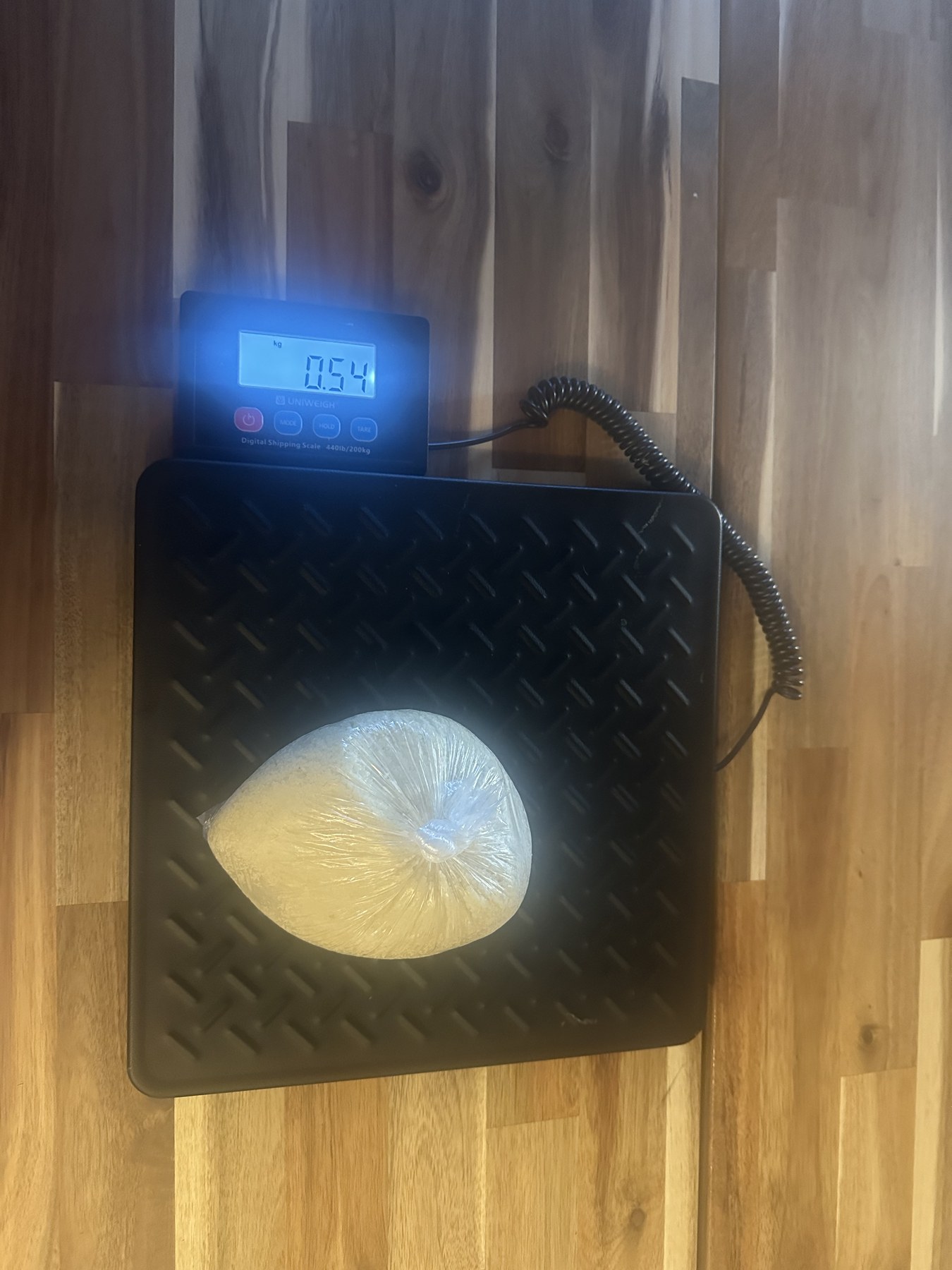 Boule d’attiéké sur une balance affichant 0,54 kilogramme.